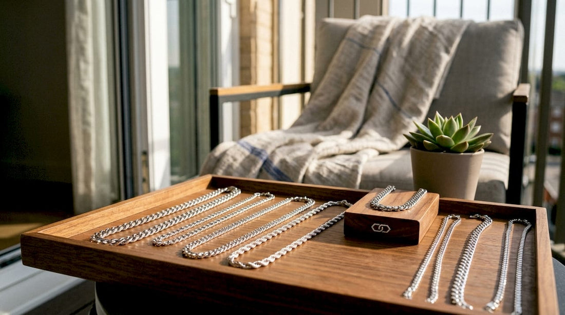 Assorted men's silver necklaces on wooden tray