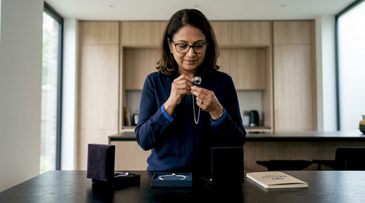 Woman inspecting silver necklace closely