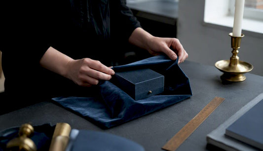 Hands wrapping jewelry gift box neatly