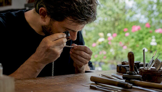 Artisan inspecting sterling silver chain hallmark close-up