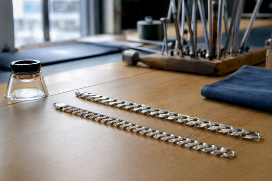 Close-up of silver curb and Cuban chains side by side