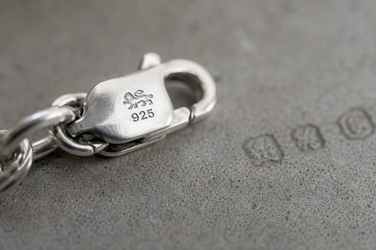 Close-up of lion passant hallmark on silver chain clasp