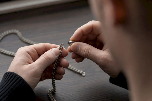 Hands testing silver chain clasp with magnet