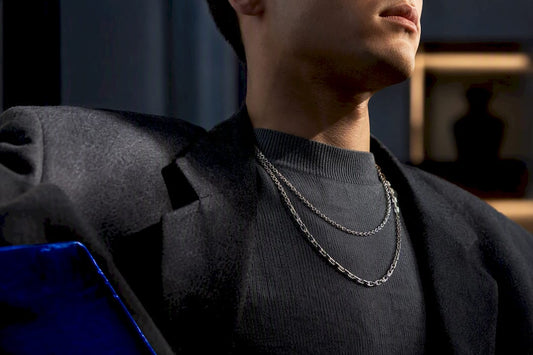 Layered silver chains on a tailored outfit