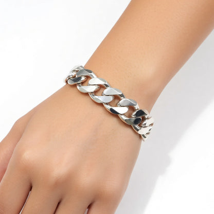 Silver chain bracelet on a wrist against a white background