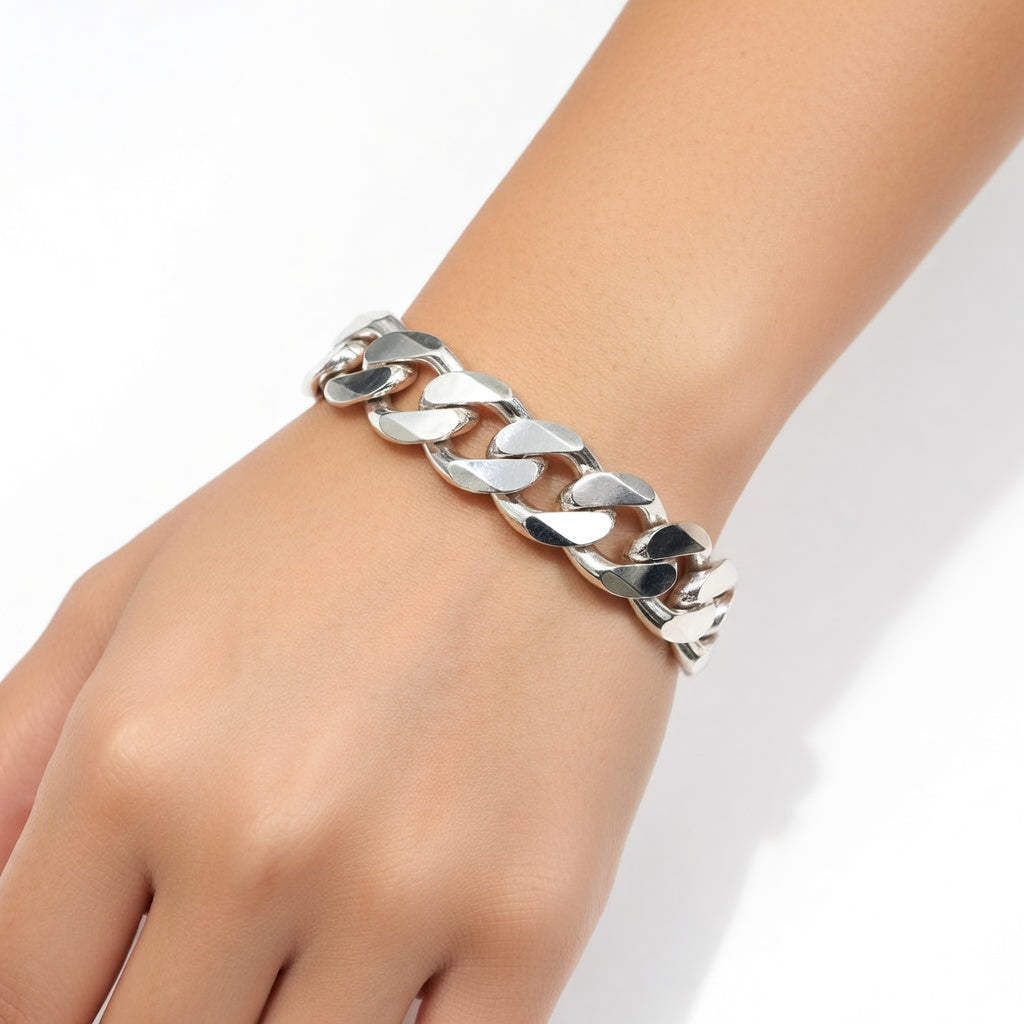 Silver chain bracelet on a wrist against a white background