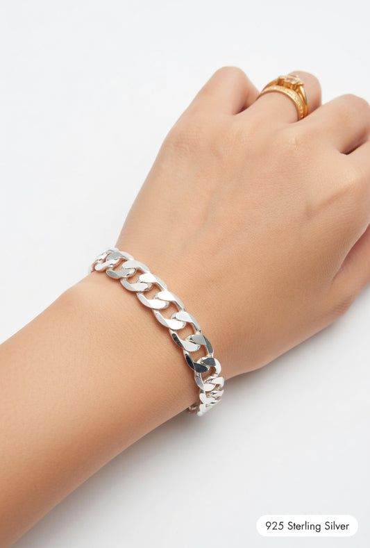 Silver chain bracelet on a wrist with a plain background