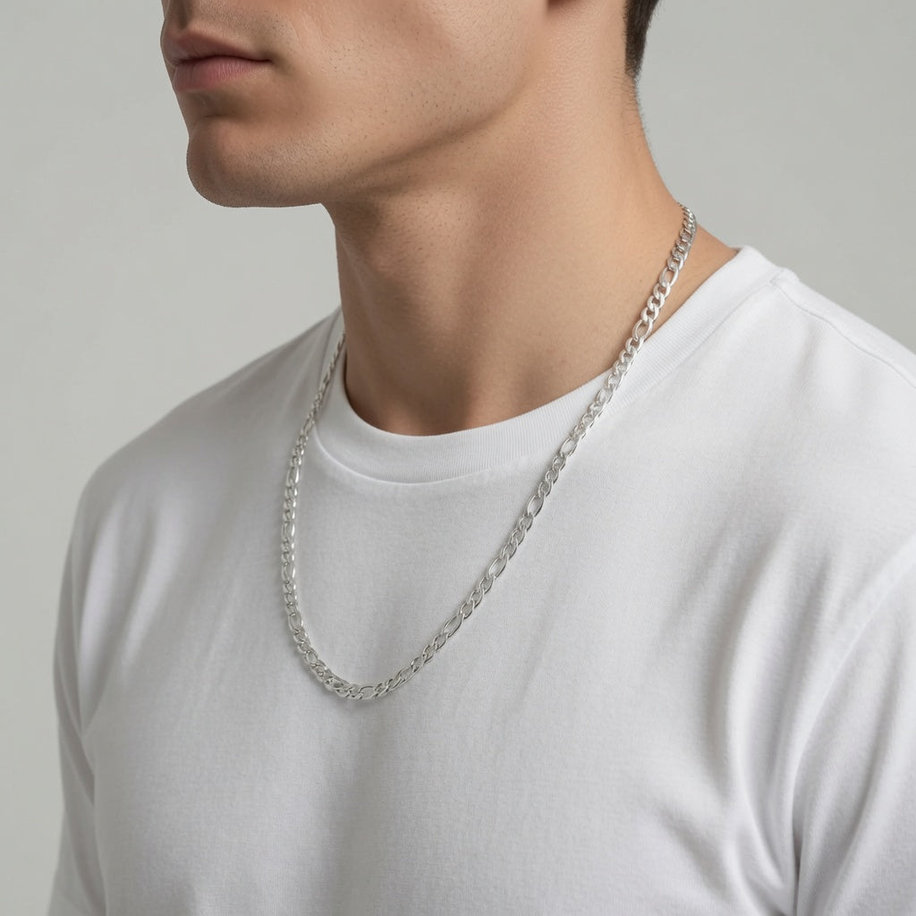 Man wearing a 4mm sterling silver figaro chain necklace against a plain background
