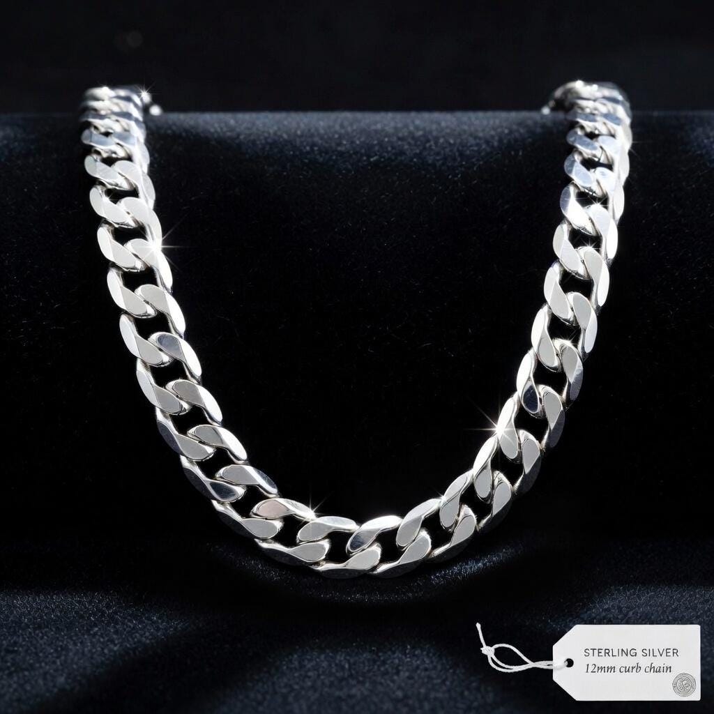 Silver chain necklace on a dark background with a tag indicating 'Sterling Silver 12mm curb chain'.