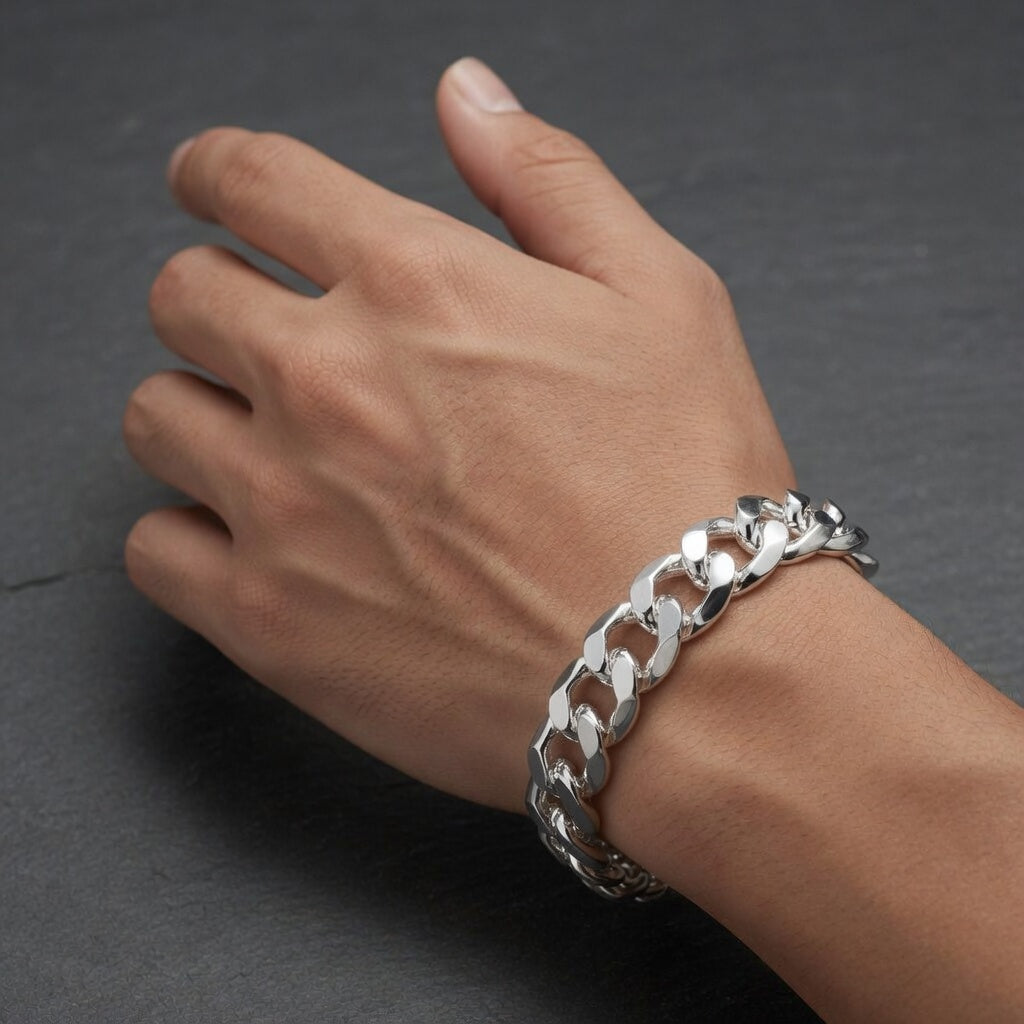 Silver chain bracelet on a person's wrist against a dark background