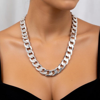 Silver chain necklace on a model against a neutral background