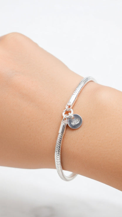 Silver bracelet on a wrist with a clear background